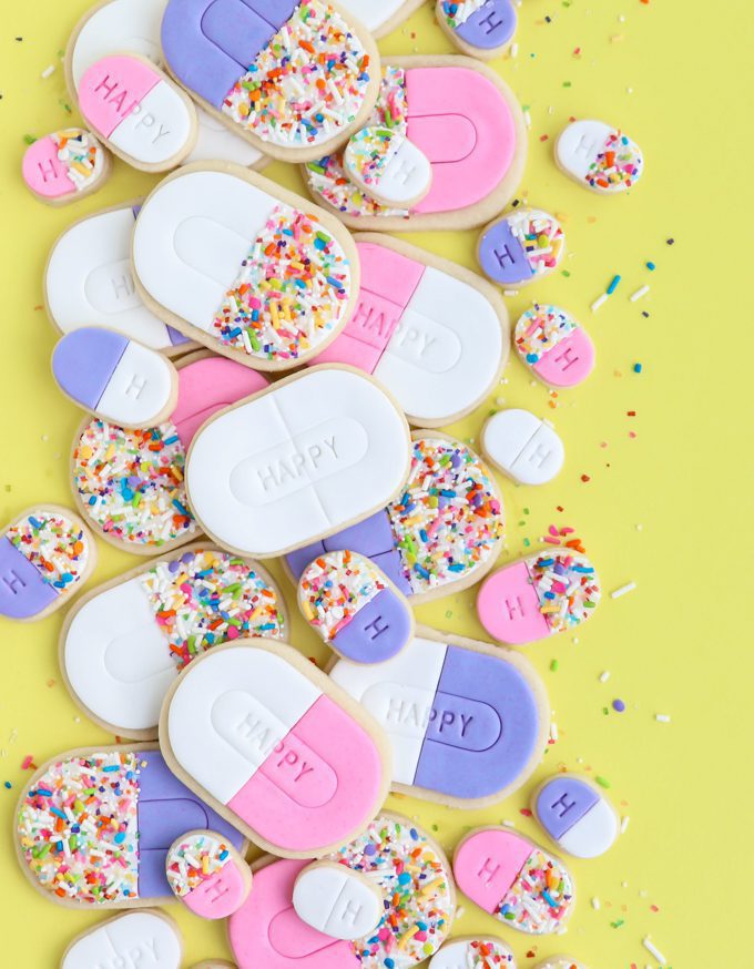 happy pill cookies on yellow backdrop