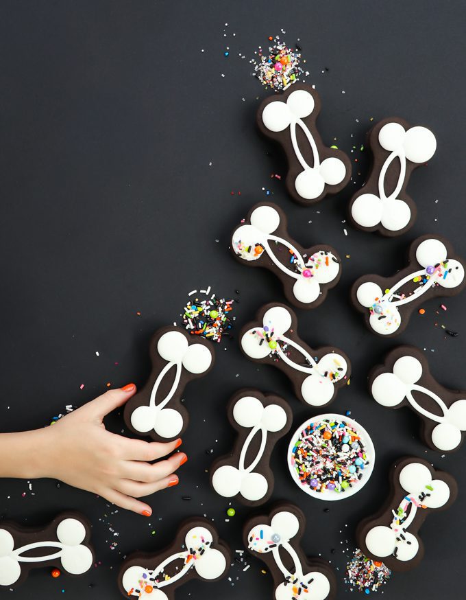 Halloween Bone Cookies with sprinkles on black and a hand