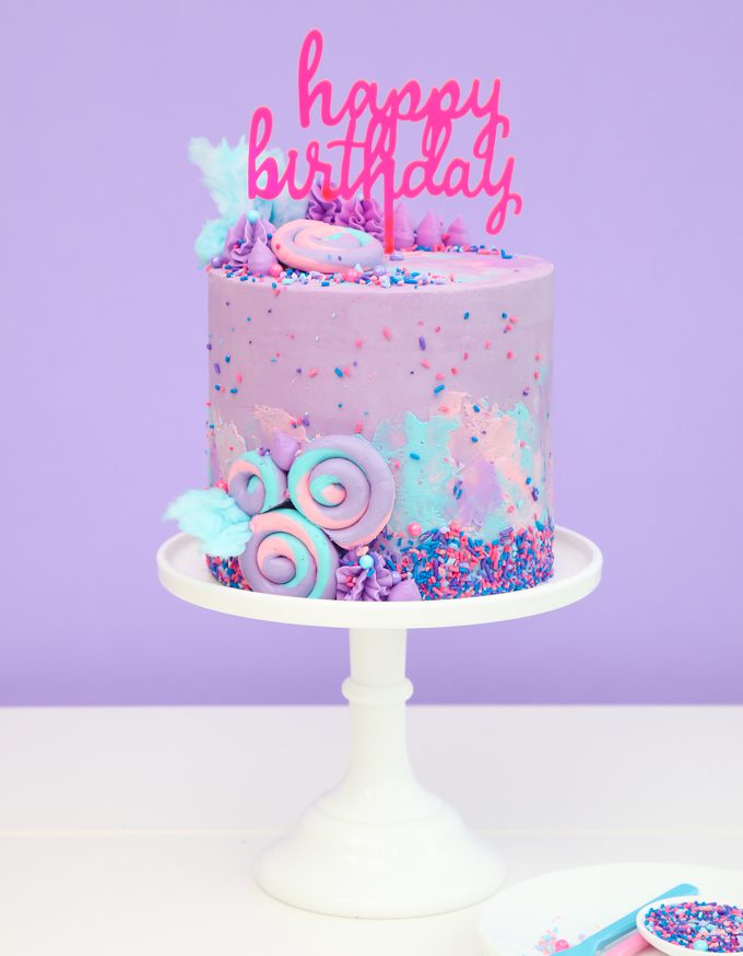 purple cotton candy cake with sprinkles and cake topper