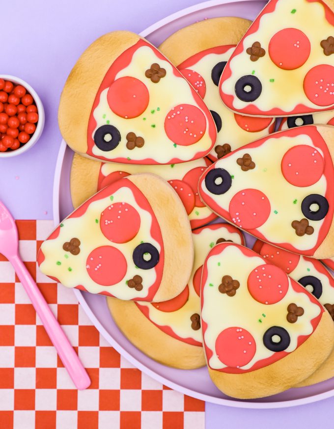 pizza cookies stacked up with red checked napkin and purple backdrop