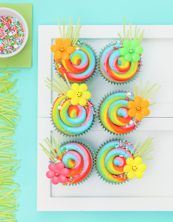 Rainbow swirl cupcakes with edible grass.