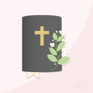Clipart of a black bible with a gold cross, a cream colored bookmark out the bottom and greenery with white blooms to the left.