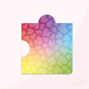 Clipart of a puzzle piece with a rainbow print in primary colours with a faint white heart pattern.